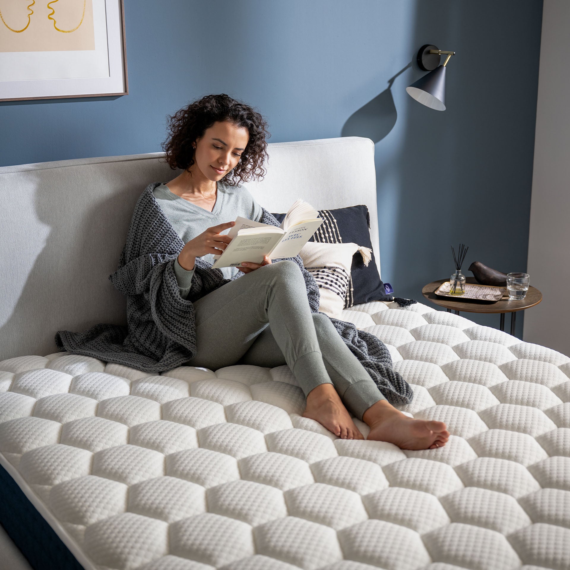 Photo d'une femme entrain de lire et de se détendre sur le Matelas hybride premium Jade - mémoire de forme