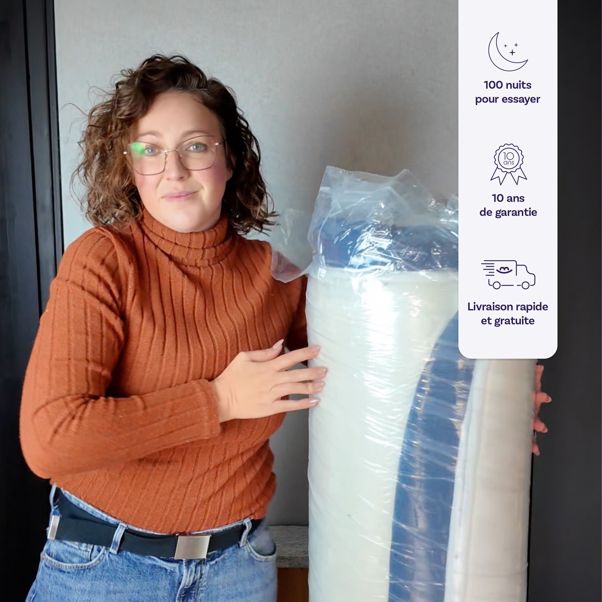 Photo d'une cliente satisfaite avec dans ses mains le matelas Victoria encore sous emballage à sa réception. 100 nuits pour essayer. 10 ans de garantie. Livraison rapide et gratuite.