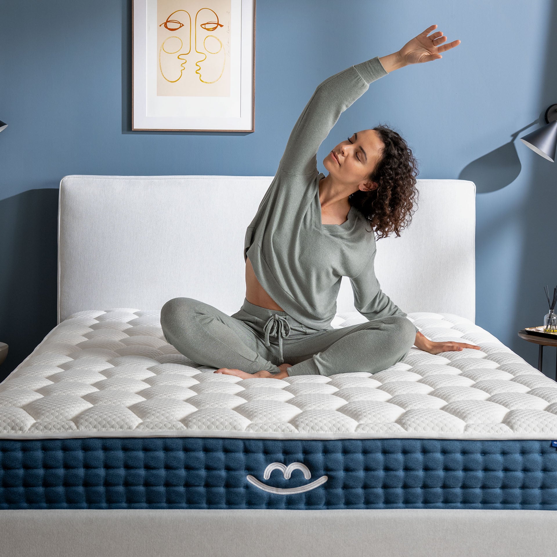 Photo d'une femme entrain de méditer et de s'étirer sur le côté, assise sur le matelas Jade de Morphea Bed